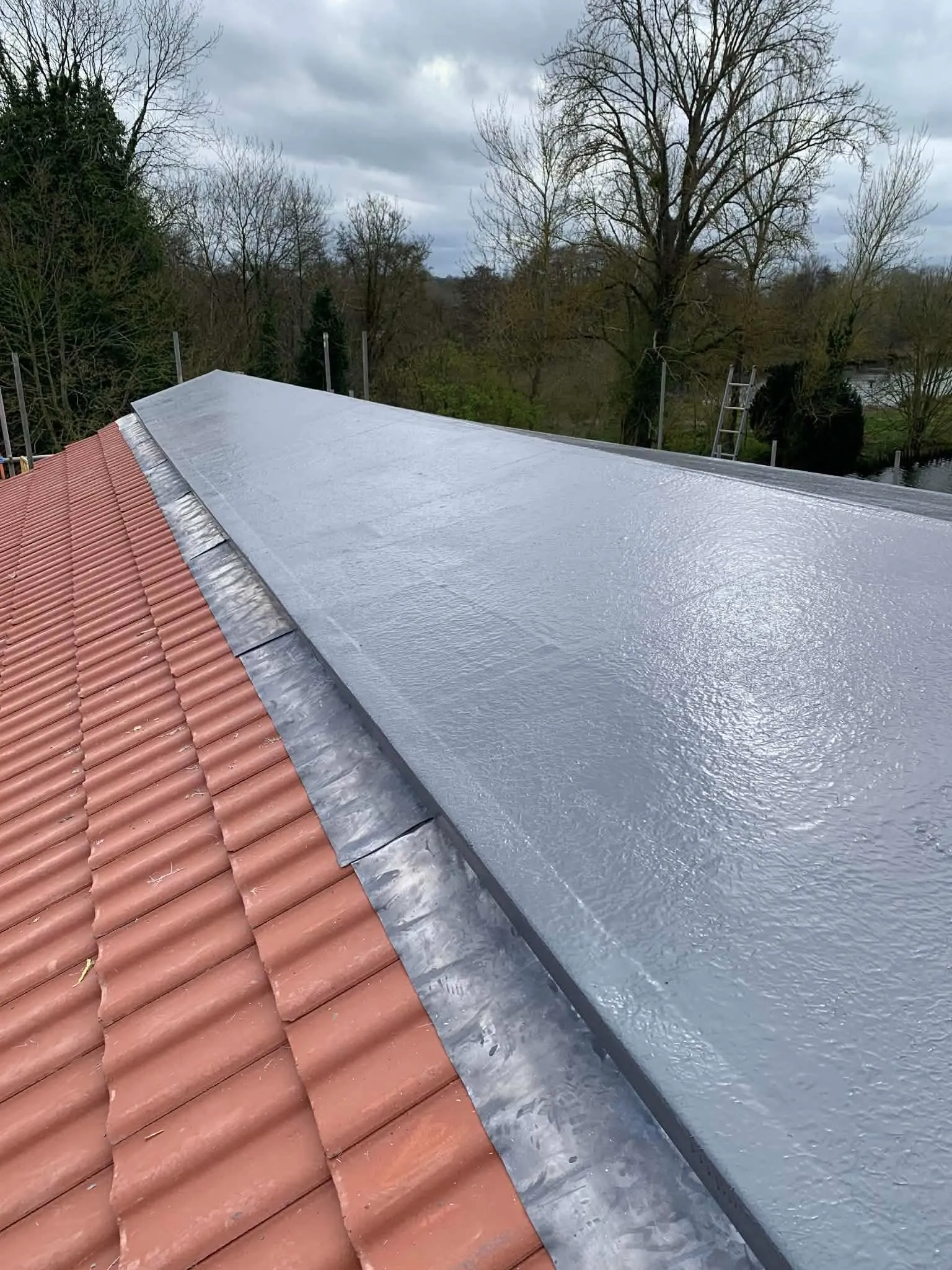 New fibreglass flat roof seamlessly joined to a red clay-tiled pitched roof